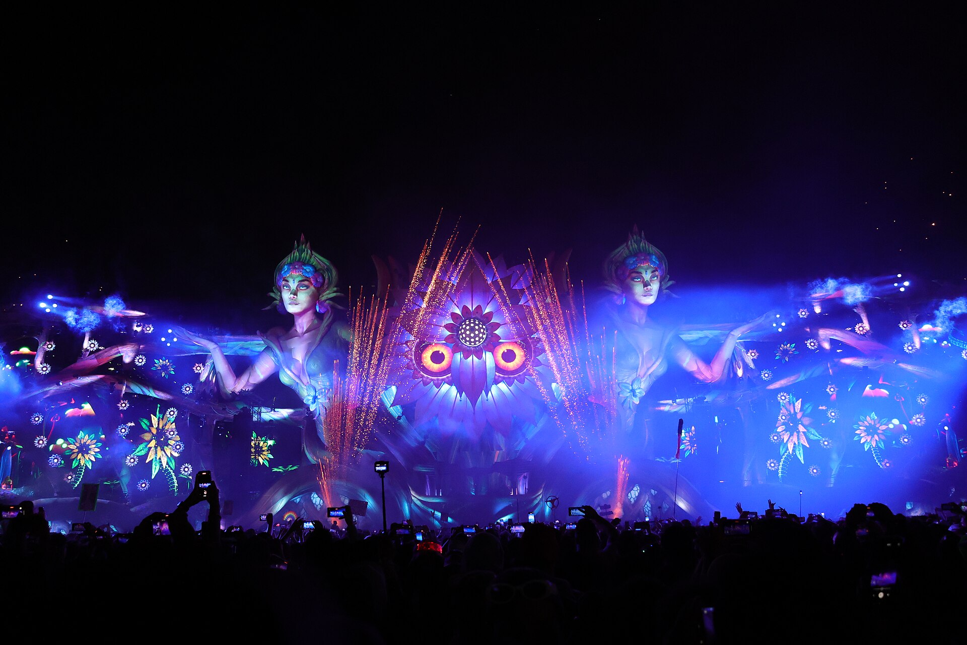 Festival-goers holding up phones to film the Kinetic Field stage at EDC Orlando at night