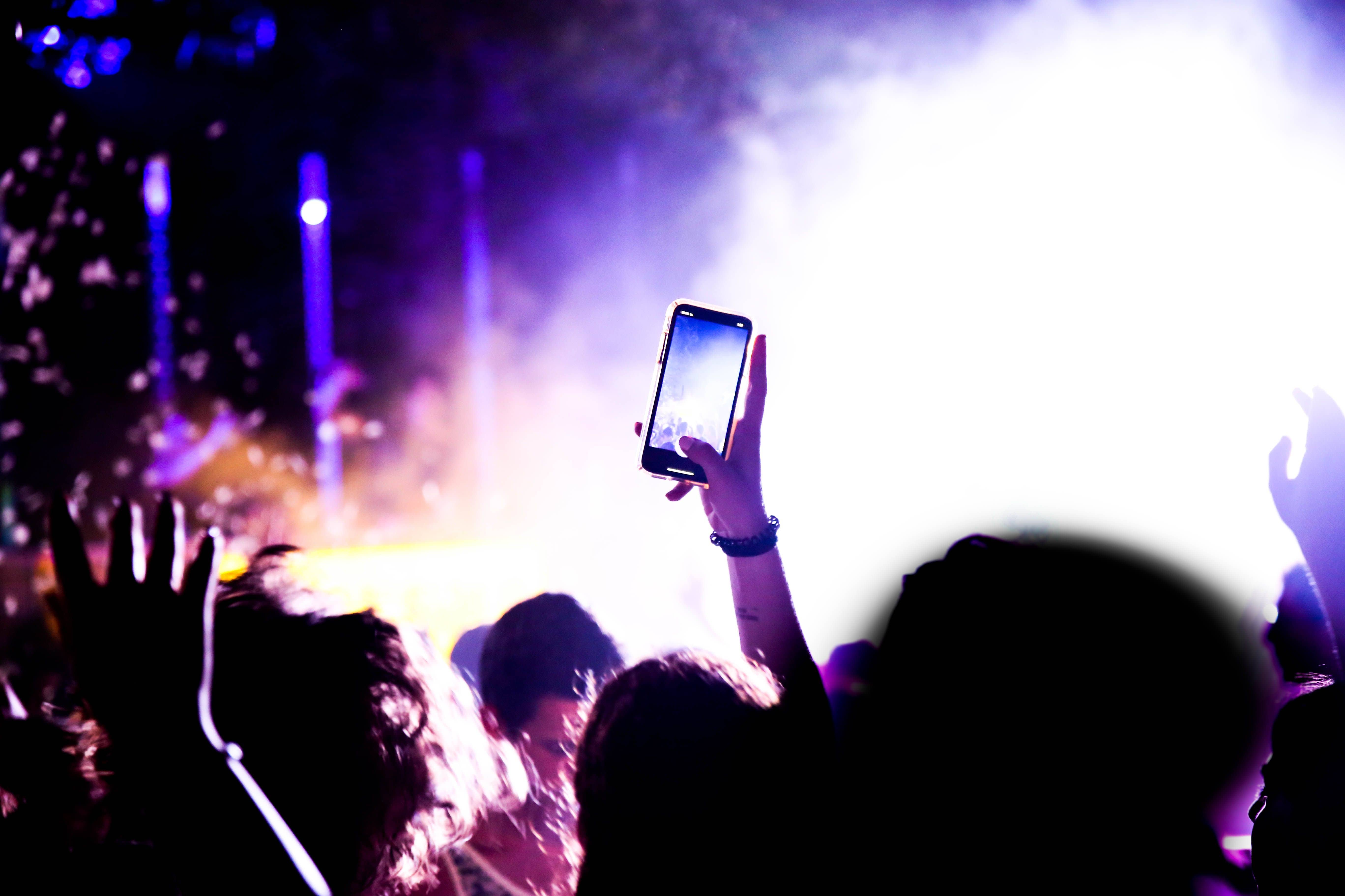 Crowd of visitors holding phones to film a laser and fountain show at Al Wathba