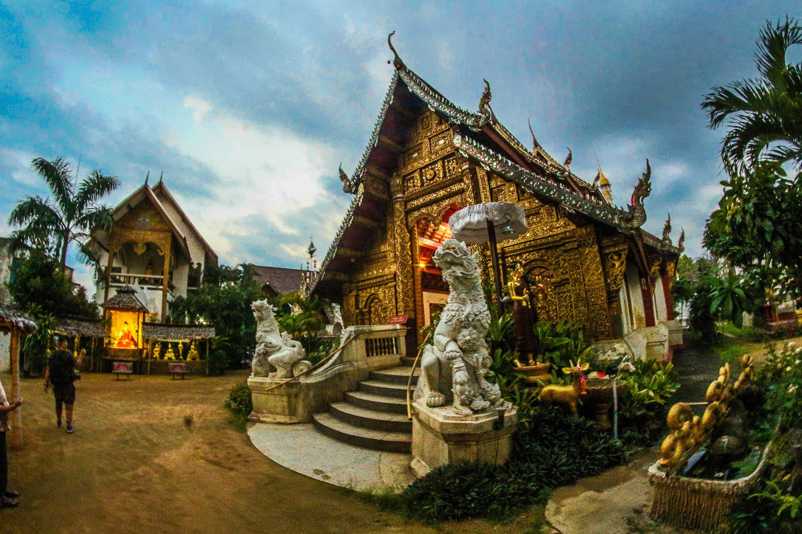 Tha Phae Gate in Chiang Mai at night decorated with hanging lanterns and crowds gathered for the Yi Peng parade