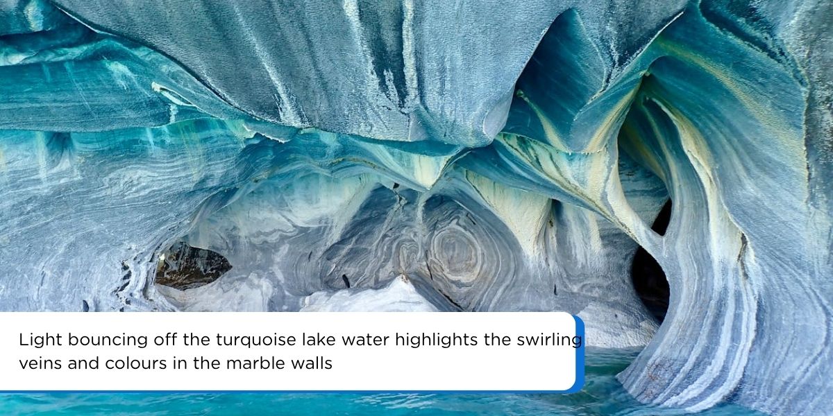Close up of blue grey marble rock inside the caves with swirling veins and reflected light from the water