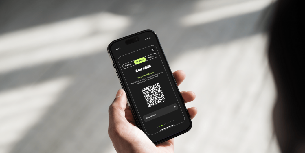 User holding smartphone displaying eSIM QR code setup screen