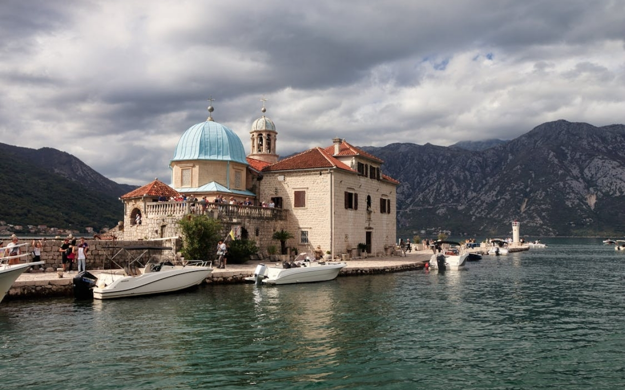 Narrow swimming area along the Bay of Kotor with mountains surrounding the coastline