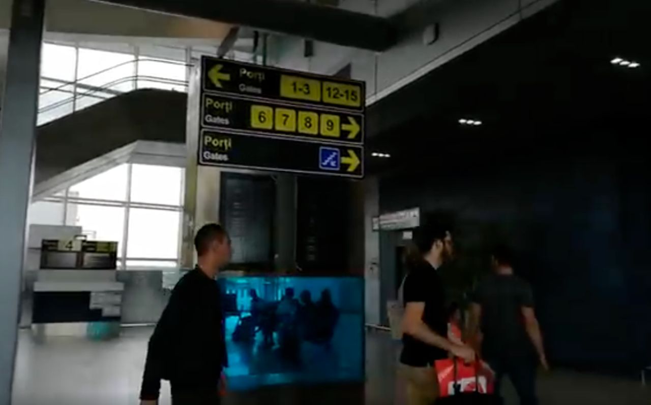 Travelers arriving at Bucharest airport using smartphones for navigation