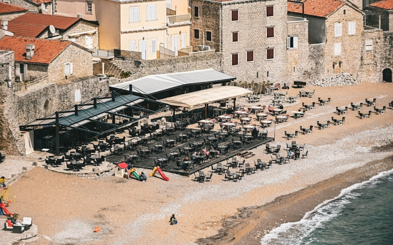 Pebble beach near Budva with clear water and coastal town buildings in the background