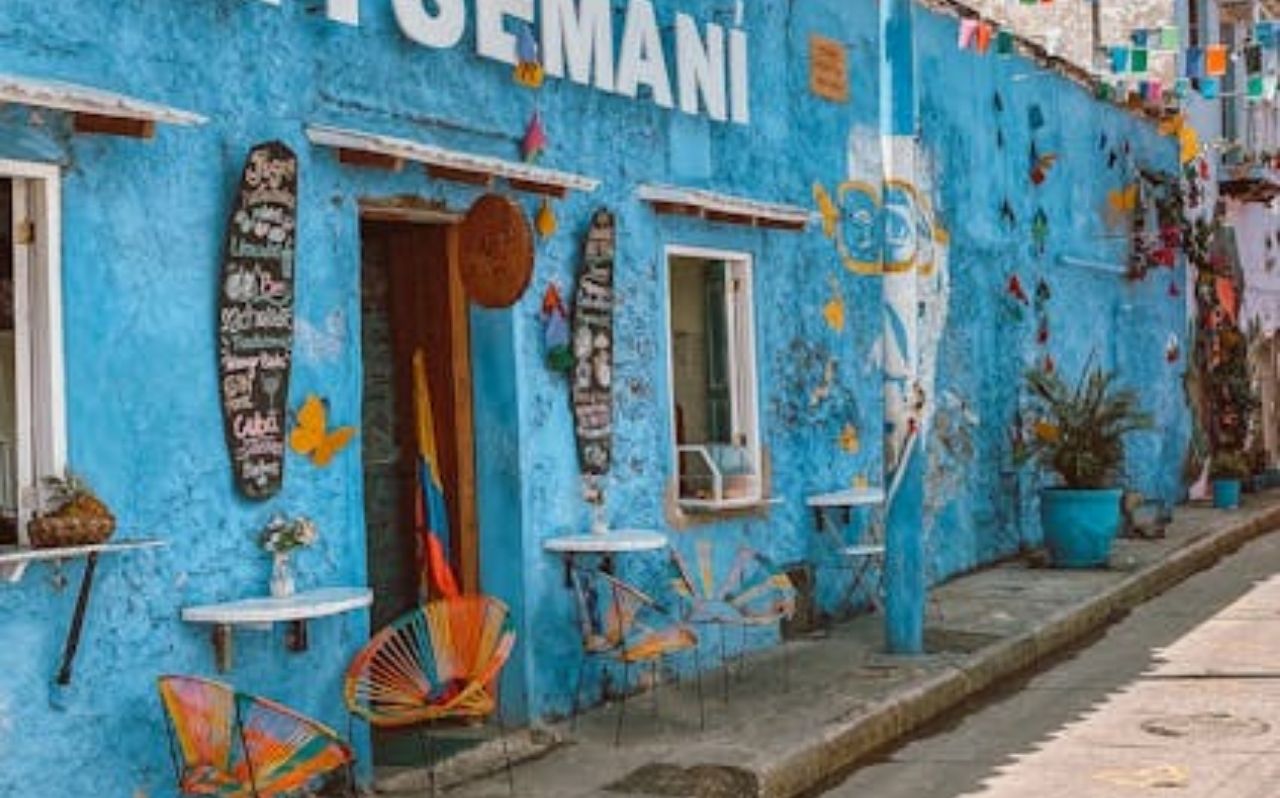 Colorful street in Getsemaní neighborhood Cartagena Colombia with blue wall and outdoor seating