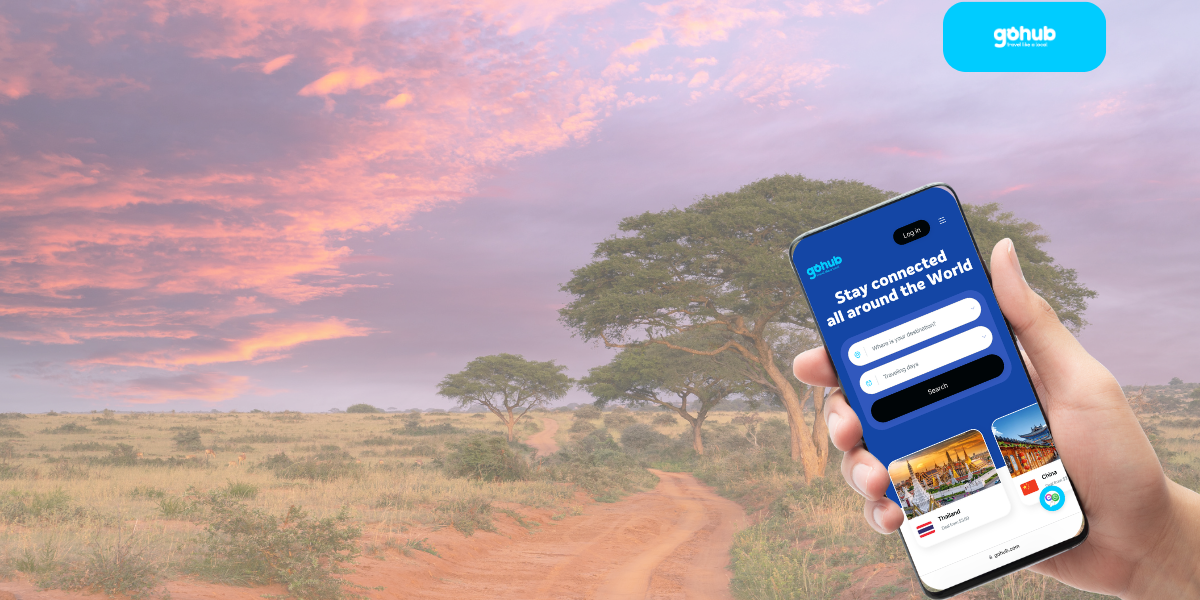 A hand holding a smartphone with the Gohub eSIM interface overlaid on an African savannah at sunset
