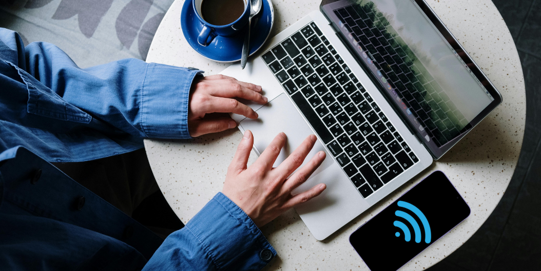 Digital nomad using laptop connected via smartphone hotspot during travel