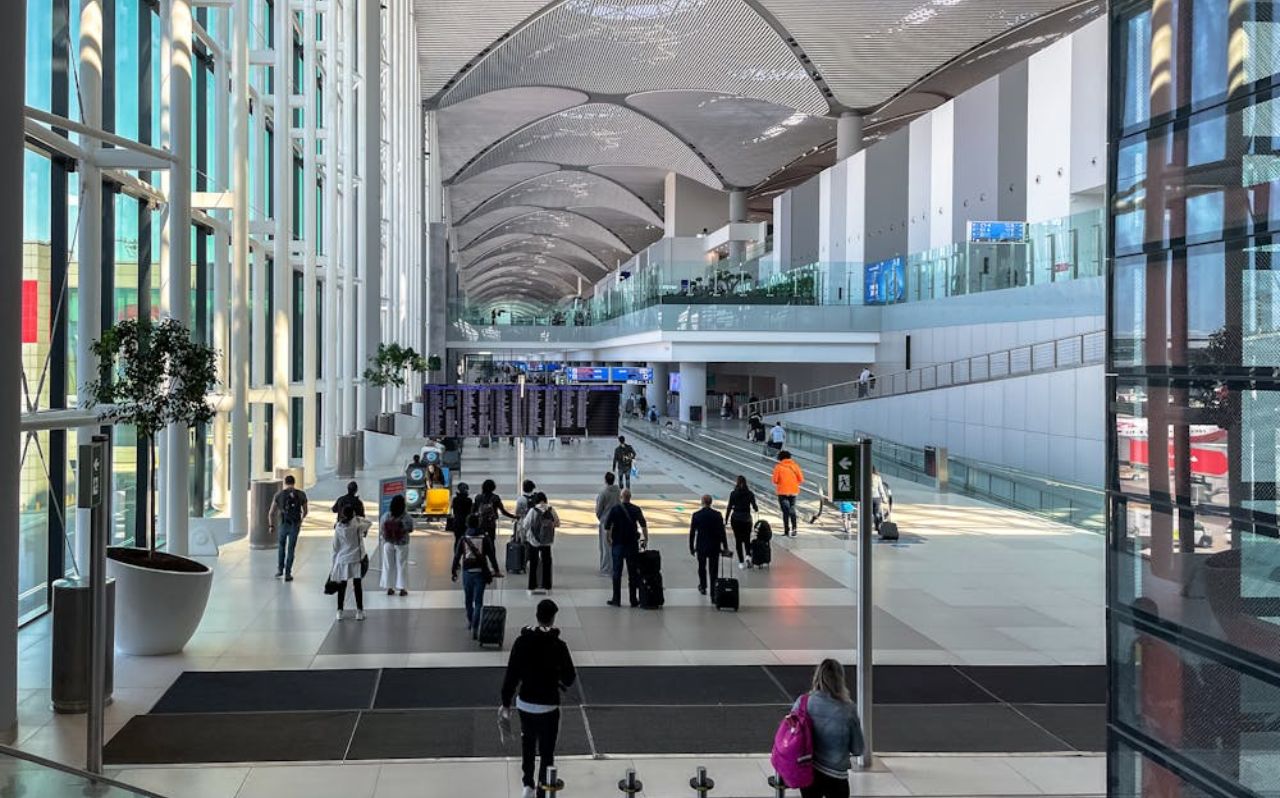 Travelers inside Istanbul Airport arrivals hall checking transport directions
