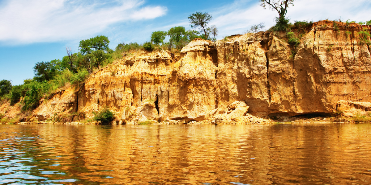 Golden sandstone cliffs reflecting on the Nile River in Murchison Falls National Park, Uganda