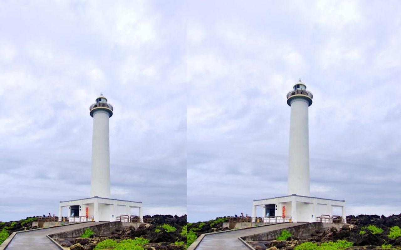 White lighthouse standing on rocky coastline in Okinawa