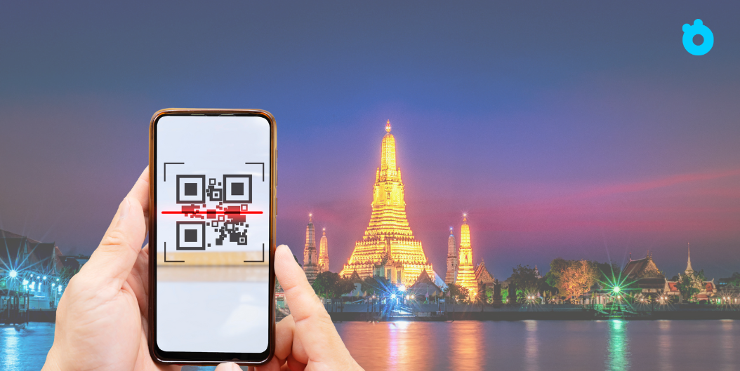 Traveler scanning a QR code to activate eSIM in front of Wat Arun temple in Bangkok, Thailand
