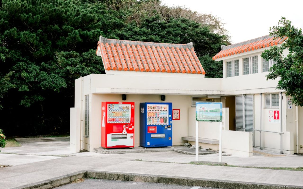 Traditional Okinawan building with red tile roof and vending machines