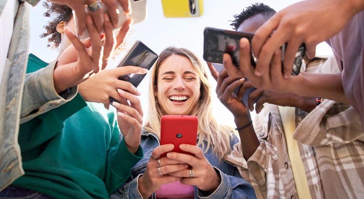 Hình ảnh nhóm bạn du lịch cùng chia sẻ kết nối mạng qua một thiết bị cài eSIM tốc độ cao