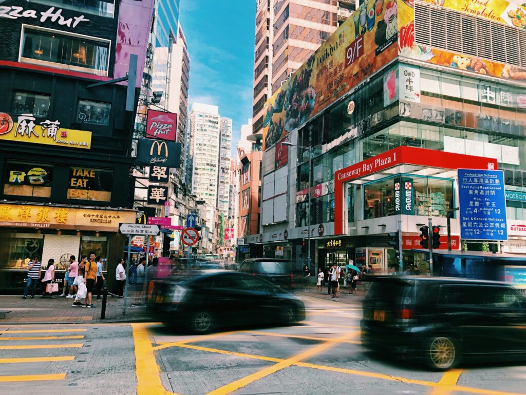 Khu mua sắm sôi động tại Causeway Bay, Hong Kong với nhiều thương hiệu lớn và dòng xe tấp nập – Điểm đến lý tưởng cho tín đồ shopping khi du lịch tự túc.